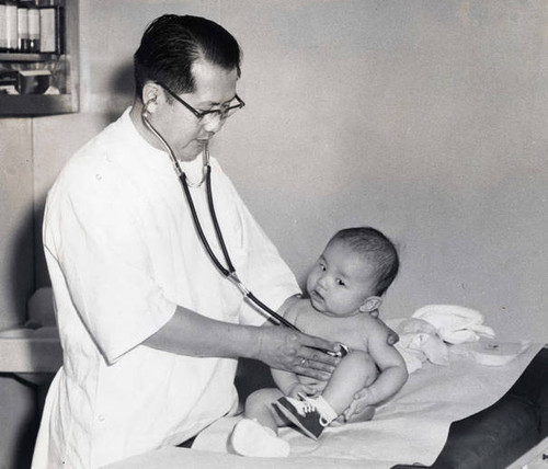 Dr. Julius Sue giving a baby a check-up