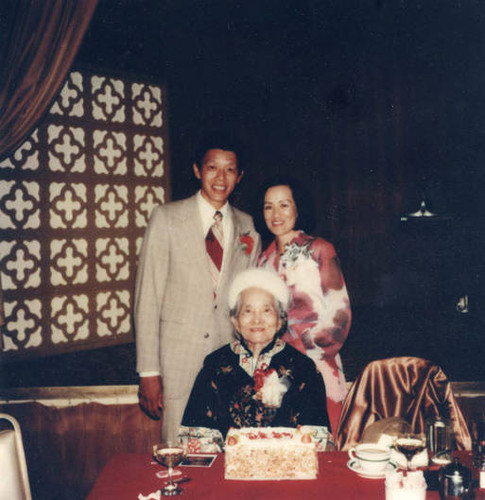 Dan Louie Jr., Esther Kwok Louie and Ko Po Kwok celebrating a birthday at a restaurant