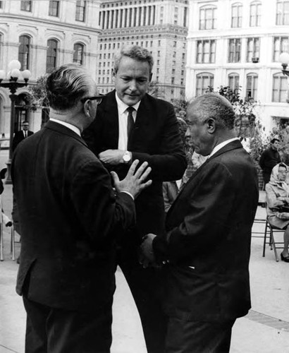 Gilbert Lindsey standing in Plaza with two men