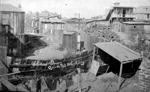 Chinese Den, opium and washing. Firehouse on left, Ft. Moore Hill, Lugo House at right. "So this is Nigger Alley - Ferguson Alley." Reproduced through the courtesy of the Bancroft Librarym University of California, Berkeley, CA. From Los Angeles A City Apart: An Illustrated History by David L. Clark