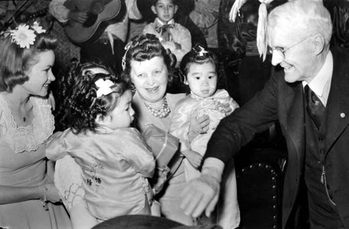 Los Angeles Times press release photo of Harry Chandler's Birthday. The photo is of June Sterling, Mo-Fong Loo, Mrs. Christine Sterling, Mo-Ping Loo and Harry Chandler, and the photographer is Butch
