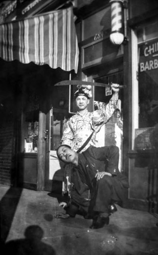 "Headchoppers" on Spring Street in front of a barber shop and to the left Tom's curio store, Tom G. costume