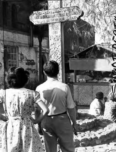 Man and woman staring at Olvera Street cross