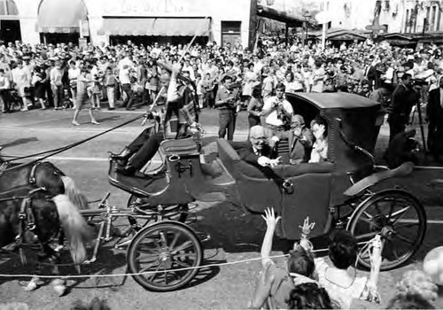 Gilbert Lindsey riding in coach in a parade