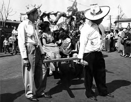 Men pulling a cart filled with people at the Blessing of the Animals