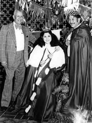 Cruz Ledesma, and woman crowned as king and queen of Mardi Gras posing with Mario Valadez