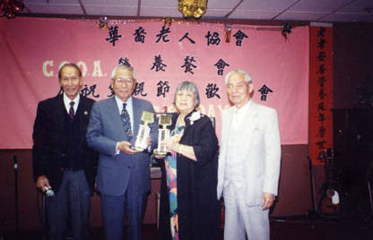 Lily Chan, president of the CCOA, awarding Wilbur Woo, a representative from Cathay Bank, who donated $10,000 to the CCOA Nutrition Department. The money came from the proceeds of a Golf Tournament. Wilbur Woo is in the middle and Lily Chan is on the right