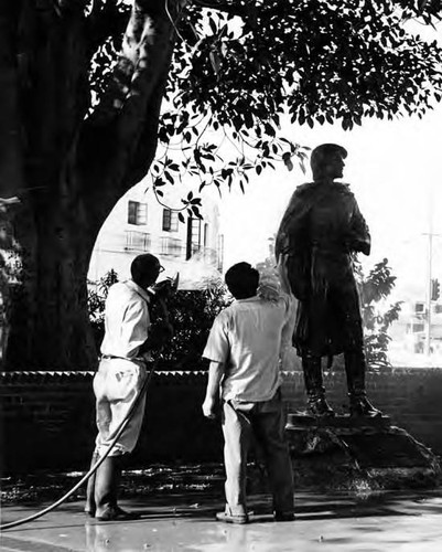 Men washing statue of Phillipe de Neve near kiosko