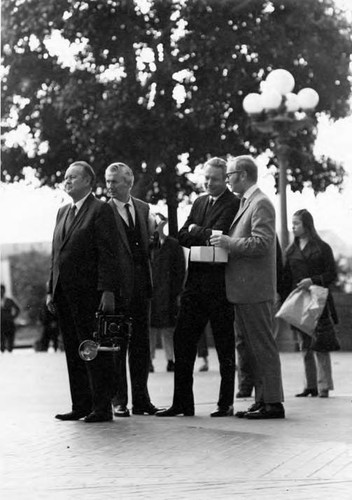 Four men, one with a camera, in the Plaza