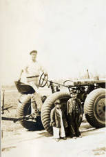 Jake Siu standing on the Massey-Harris with two Siu boys standing in front