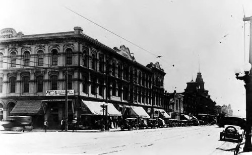 Pico House when it was the National Hotel, with awnings and cars parked in front