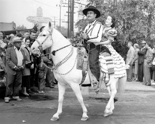 Man and woman riding on the same horse