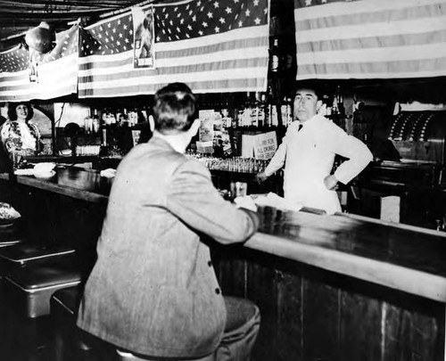 Interior of the La Golondrina Cafe, with batender and customer