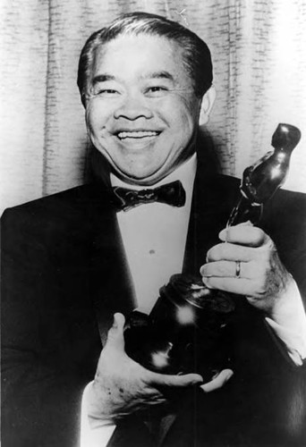 Photograph of cinematographer James Wong Howe holding an Oscar