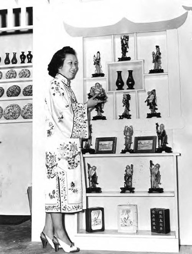 Chinese American woman in front of a display of Buddhist figures