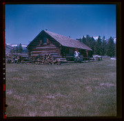 Two people in front of Hayden Cabin, 1960s