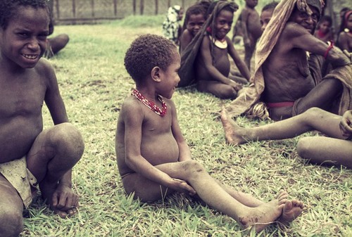 Children show mixed responses to the visitor with his camera