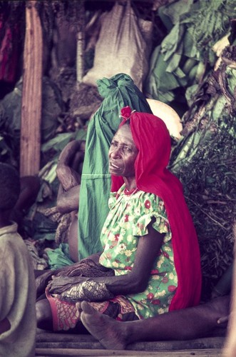 Women on the sidelines during a ceremonial pork exchange, wearing mission-approved attire