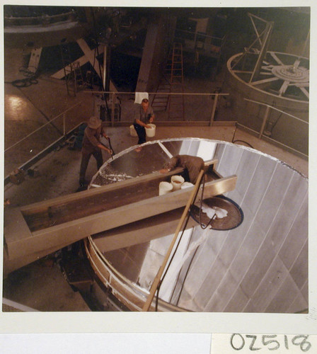 Workmen washing the 200-inch telescope mirror on the floor of the dome, Palomar Observatory