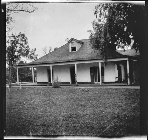 Unidentified adobe house with lawn