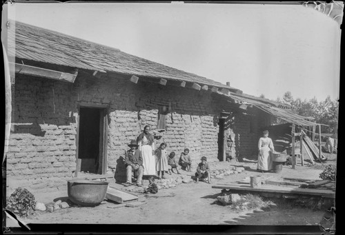 [Mexican] family outside adobe