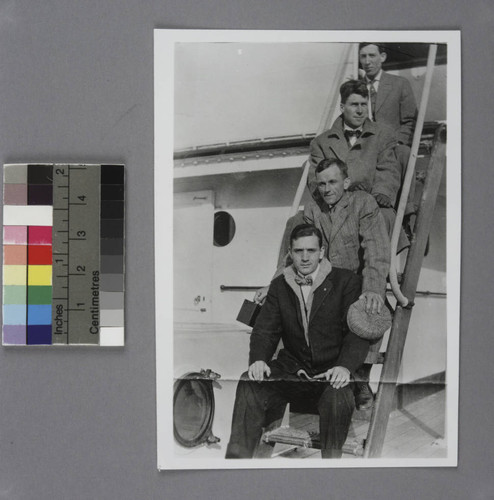 Edwin Powell Hubble and three men sitting on a ladder on a passenger ship, in transit to Oxford, England