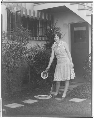 Woman using a garbage receptacle. 1929