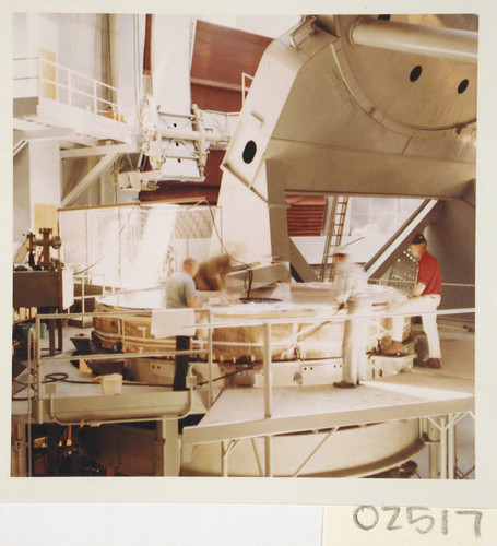 Workmen washing the 200-inch telescope mirror on the floor of the dome, Palomar Observatory