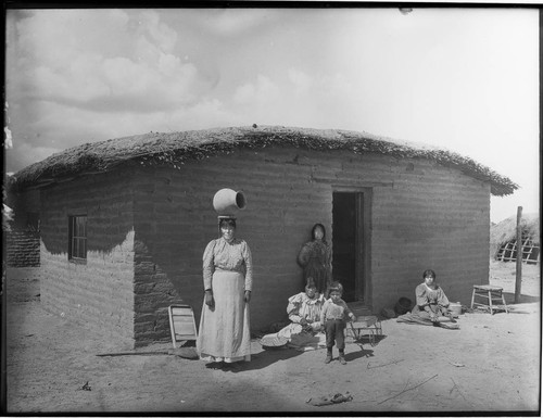 Family outside adobe structure