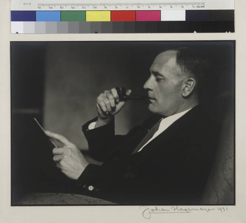 Portrait of Edwin Powell Hubble, holding a pipe, side view