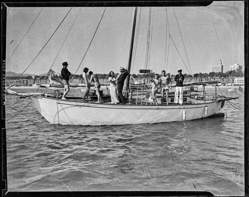 Group on a sailboat with the Santa Monica shore in the distance