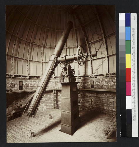 40-inch telescope and its base at Yerkes Observatory, inside the large dome, with an unidentified man standing at the controls