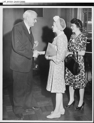 Harry Chandler shaking hands at his 77th birthday celebration