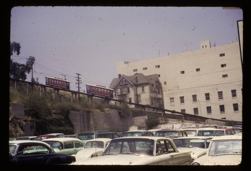 Angels Flight's two cars about to pass old house in back