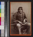 Portrait of a Yuma Indian man seated in chair, holding cane