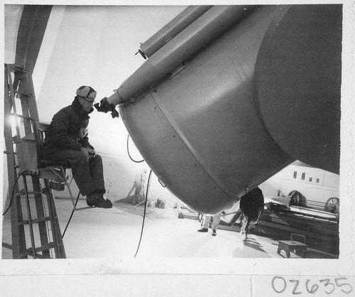 William C. Miller looking through the guidescope of the Schmidt telescope camera, Palomar Observatory