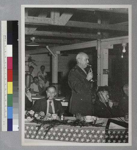 Edwin Powell Hubble seated at a party with several unidentified people
