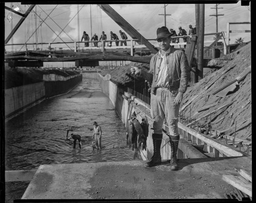 Men catching fish in a concrete lined river