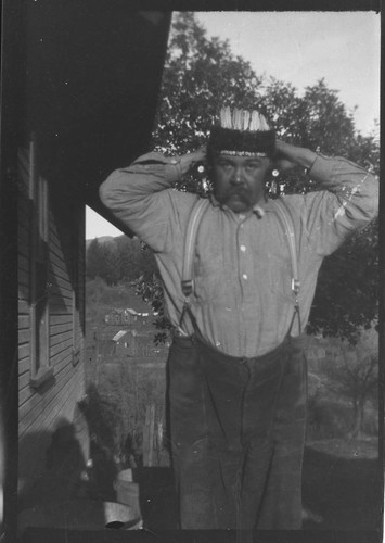 William Benson modeling a headdress and ear plugs (or ear bones)