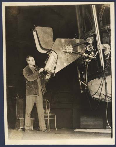 Paul W. Merrill standing at the spectrograph mounted on the 60-inch telescope, Mount Wilson Observatory