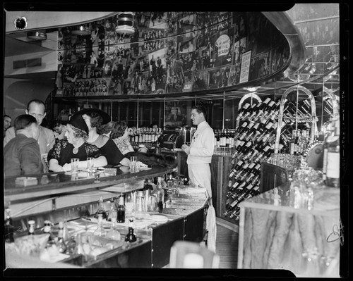 Interior of an unidentified bar, with bartender and customers