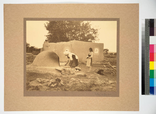 Women baking bread in oven at Acometa, a summer pueblo of the Acoma Indians