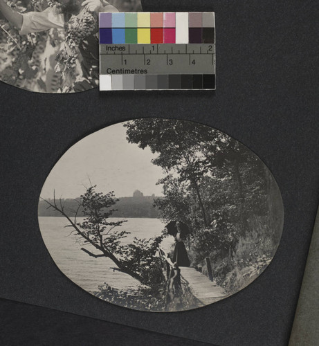 View of a woman on a boardwalk along Lake Geneva, Yerkes Observatory in the background