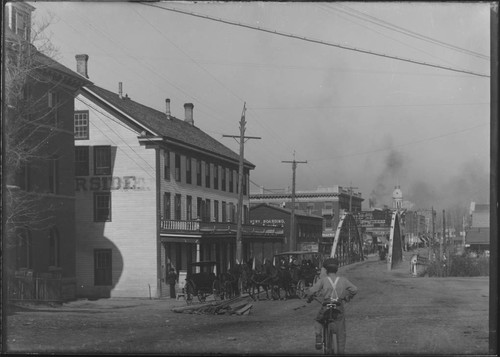 Street view of boy riding bicycle toward old Truckee Bridge, Reno, Nevada