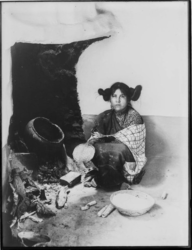 Hopi woman with basket, pot, corn
