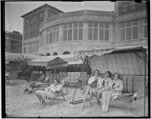 Swim team in beach chairs in front of the Club Casa del Mar, Santa Monica, California