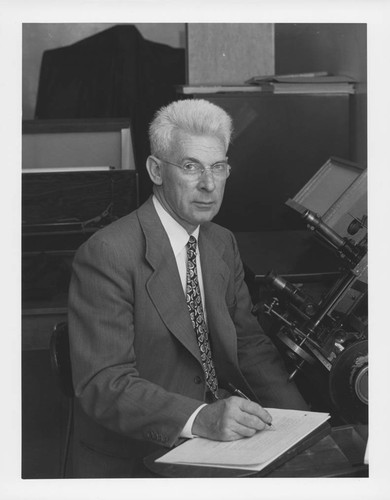 Seth B. Nicholson, sitting at a plate measuring machine