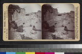 A Hopi woman working with corn in a pueblo