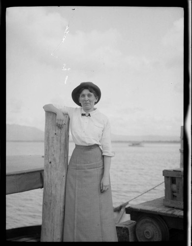 Grace Nicholson standing on a dock or ferry at a lake