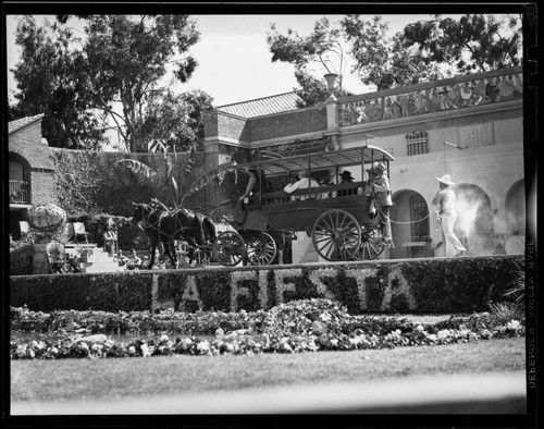 Performers in a horse drawn wagon on stage at Santa Monica High School Fiesta